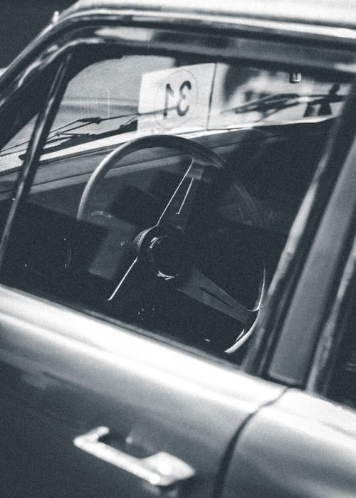 Free Monochrome view of a classic vintage car interior focusing on the steering wheel. Stock Photo