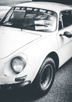 Classic Alpine A110 vintage car captured in black and white, showcasing retro design and racing heritage.