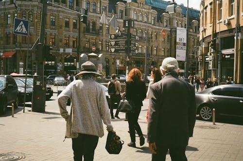 People Walking on Stone Pavement Near City Buildings