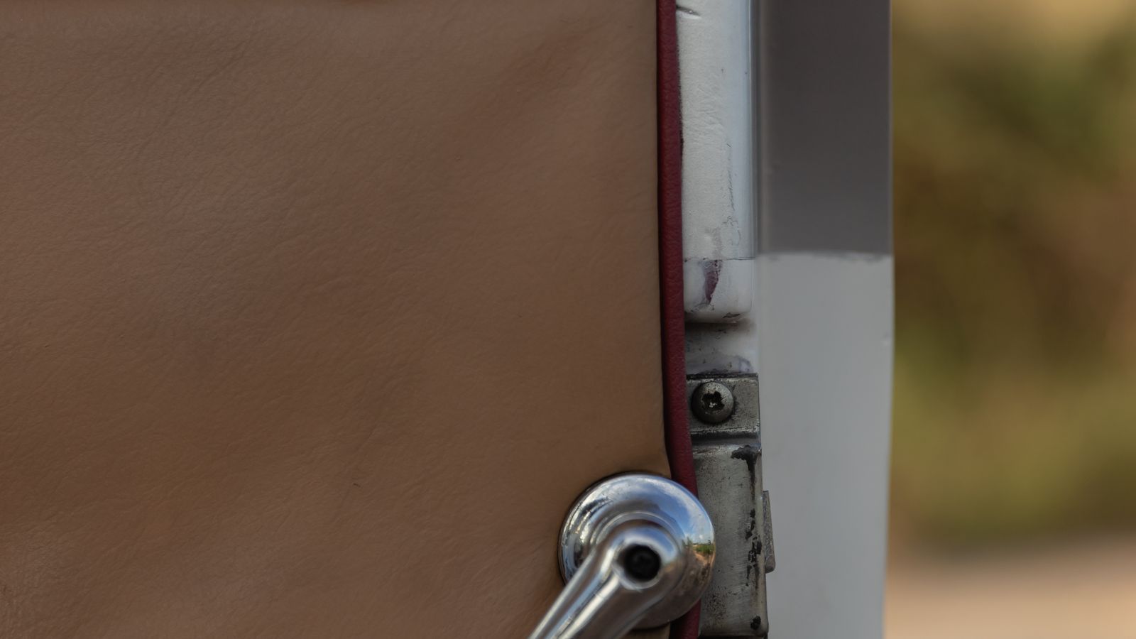 Detalhe da dobradiça e da folga entre a porta e a carroceria de um carro usado