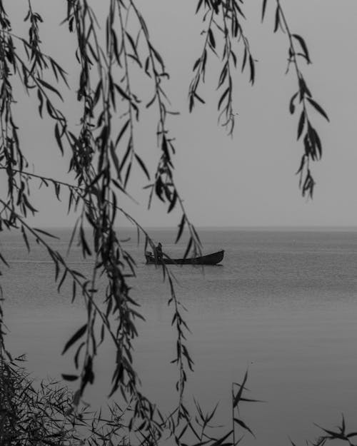 Grayscale Photo of a Boat on a Body of Water