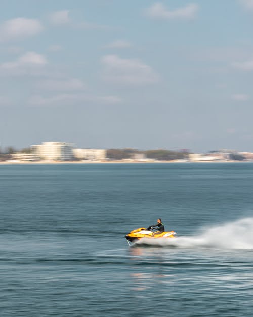 Man Riding a Jet Ski on Body of Water