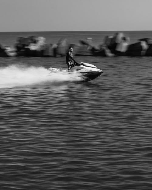 Grayscale Photo of a Person Riding a Jet Ski