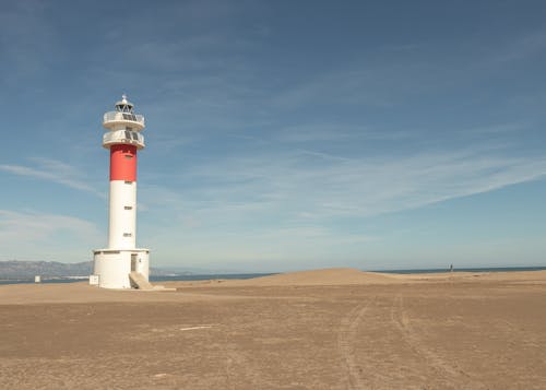 Free White and Red Lighthouse Under Blue Sky Stock Photo