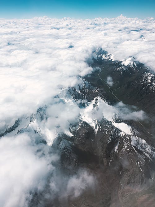 Snow Capped Mountains Covered by Clouds