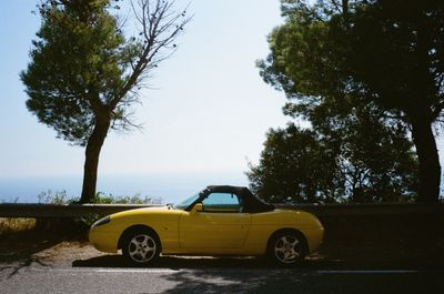 Yellow convertible parked on a coastal road, photo by Mykhailo Volkov on Pexels