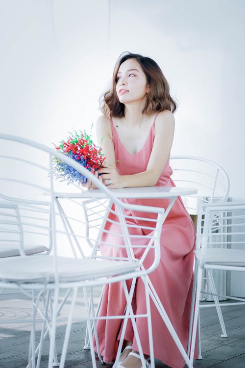 Free Woman in Pink Dress Sitting on Chair Stock Photo