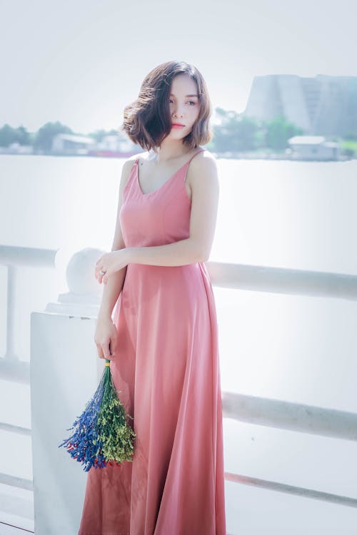 Woman Wearing Pink Spaghetti Strap Maxi Dress Holding Flowers