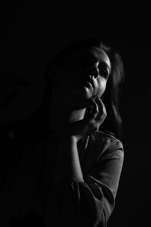 Free Moody black and white portrait of a woman in a studio setting. Stock Photo