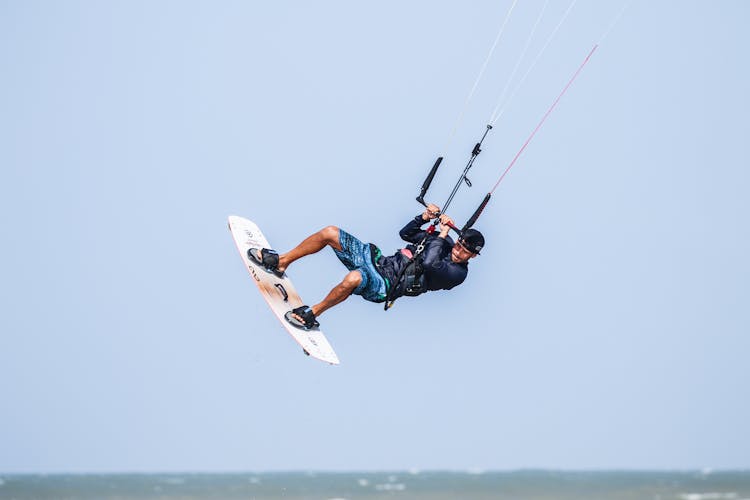 Man Flying Over Water While Windsurfing