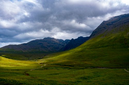 Free Dramatic cloudy sky over lush green valleys and rocky mountains in the Scottish Highlands. Stock Photo