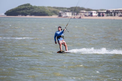 A Man Kitesurfing on Beach