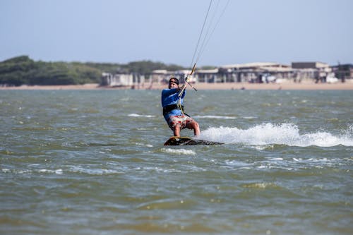 A Man Kitesurfing on the Beach