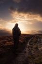 Man Standing in Muddy Field Path.