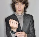 一位穿着时尚西装和高领毛衣的精致男性模特正在摆姿势