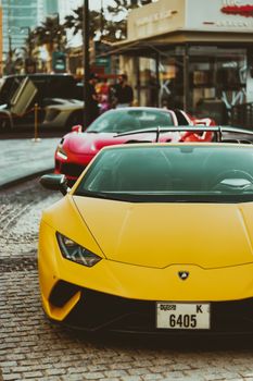 A vibrant yellow sports car captured on a lively street in Dubai, showcasing luxury and style.