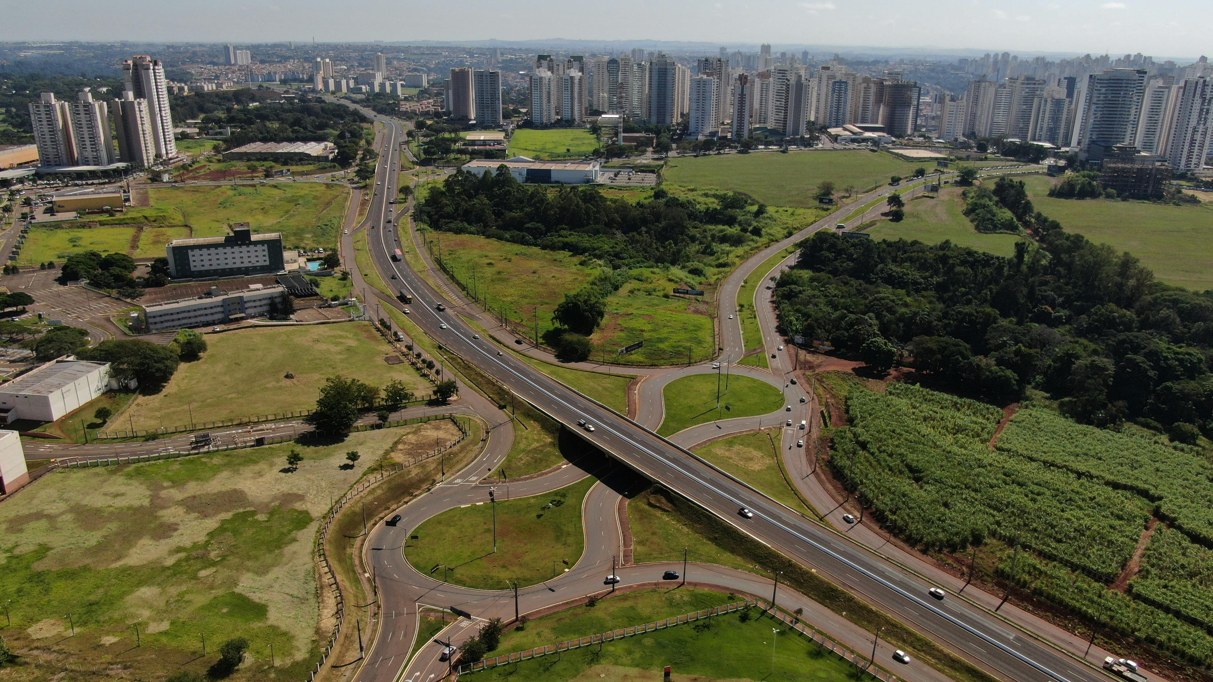 Free Aerial shot of a highway intersection in Londrina, Brazil with surrounding cityscape and greenery. Stock Photo