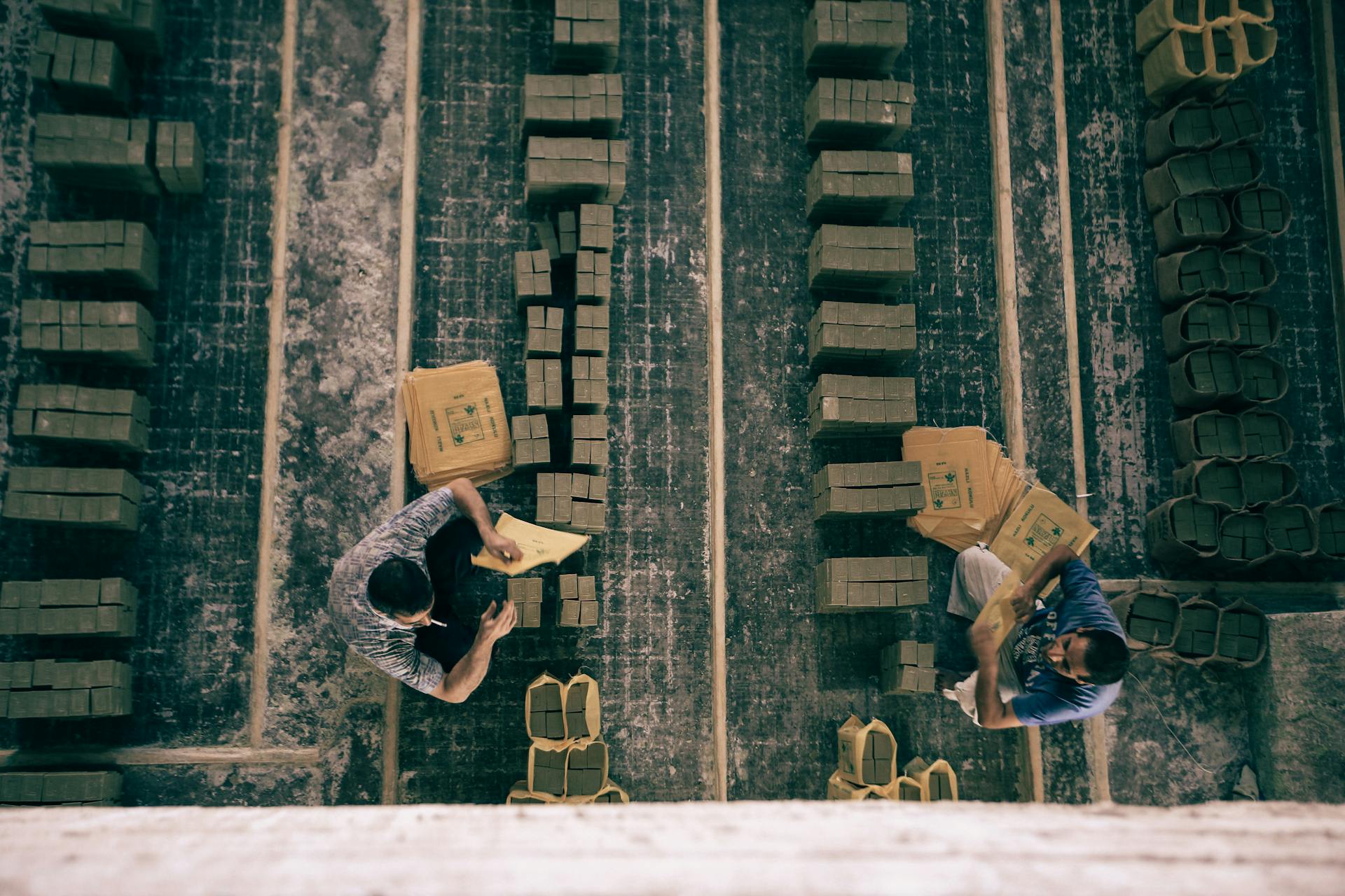 Top View of Men Sitting on Floor of Soap Factory