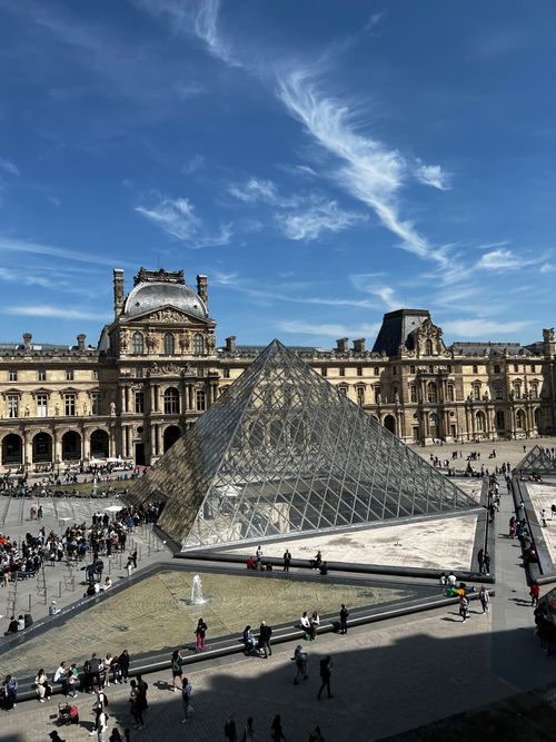 Free A captivating image of the Louvre Pyramid under a clear blue sky in Paris, France. Stock Photo