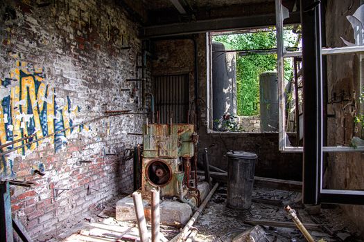 Explore a decaying industrial workshop in Leipzig, Germany, with rusted machinery and graffiti-covered walls.