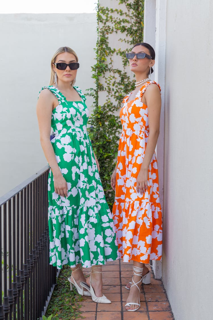 Two Women Wearing Floral Dresses Standing