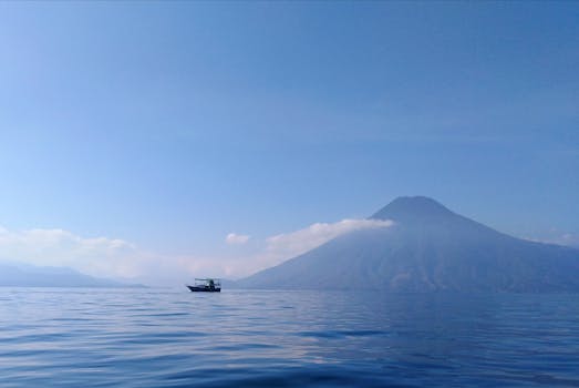 Tranquil view of Lake Atitlán and volcano surrounded by clear blue sky, Sololá, Guatemala.