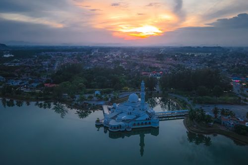 Free A mesmerizing aerial view of the floating mosque in Malaysia during sunset, surrounded by a serene landscape. Stock Photo