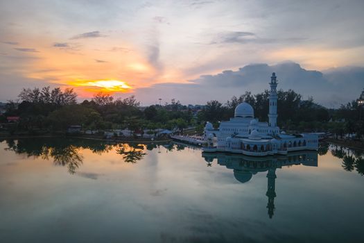 Beautiful aerial view of the floating mosque in Malaysia reflecting on the water during sunset.
