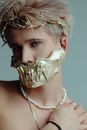 Man with Blonde Hair in a Gold Mask and a Headpiece