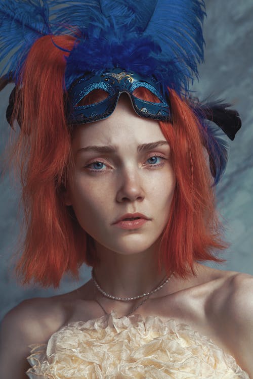 Redhead Woman with Blue Feathers and a Mask on Hear Head
