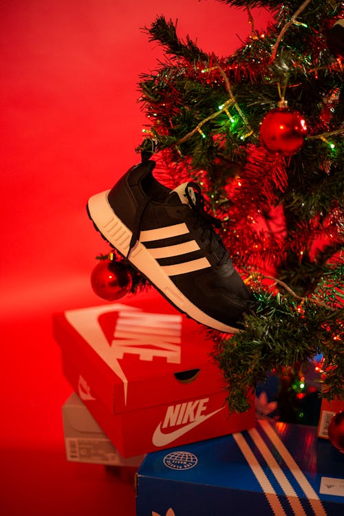 Photo of a Black and White Sneaker Near a Christmas Tree