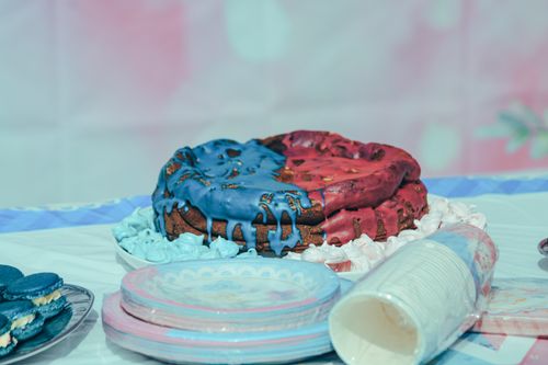Free Vibrant red and blue iced cake on a table setting with plates and cups. Stock Photo