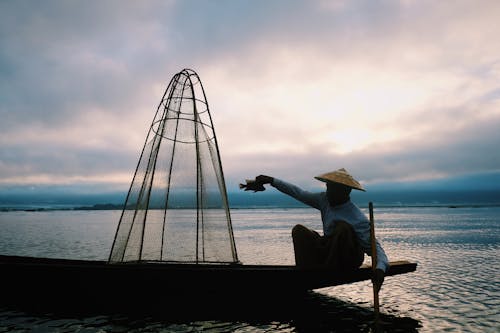 Free Photo of a Fisherman Holding a Fish Stock Photo