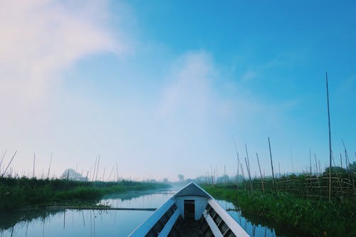 White Wooden Boat on River under Blue Sky