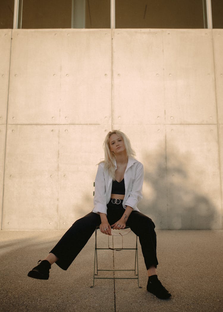 Blonde Woman Sitting On A Stool Modeling Urban Fashion