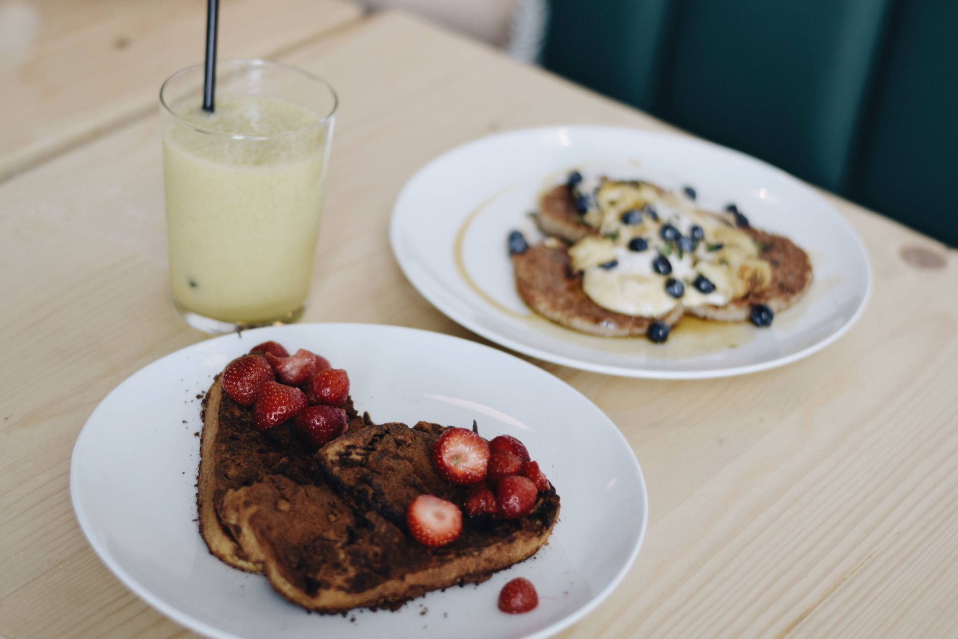 A tasty breakfast spread featuring French toast with strawberries and pancakes topped with fruits.