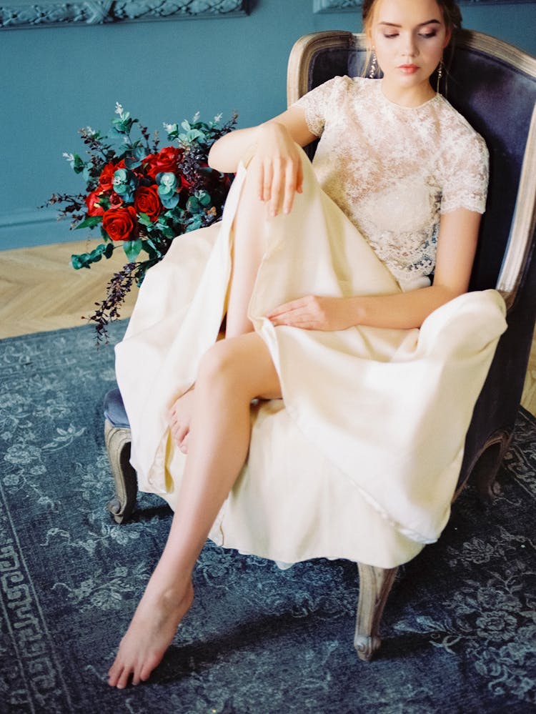 Woman In A White Lace Top Sitting On A Chair