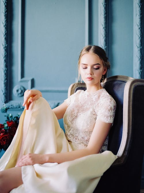 Portrait of Young Beautiful Woman Sitting in the Armchair 