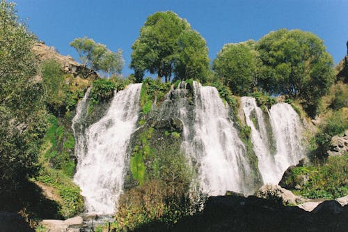 Waterfalls Near Green Trees Under Blue Sky