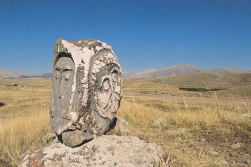 Free A prehistoric stone carving stands solitary in a sunlit grassy valley. Stock Photo