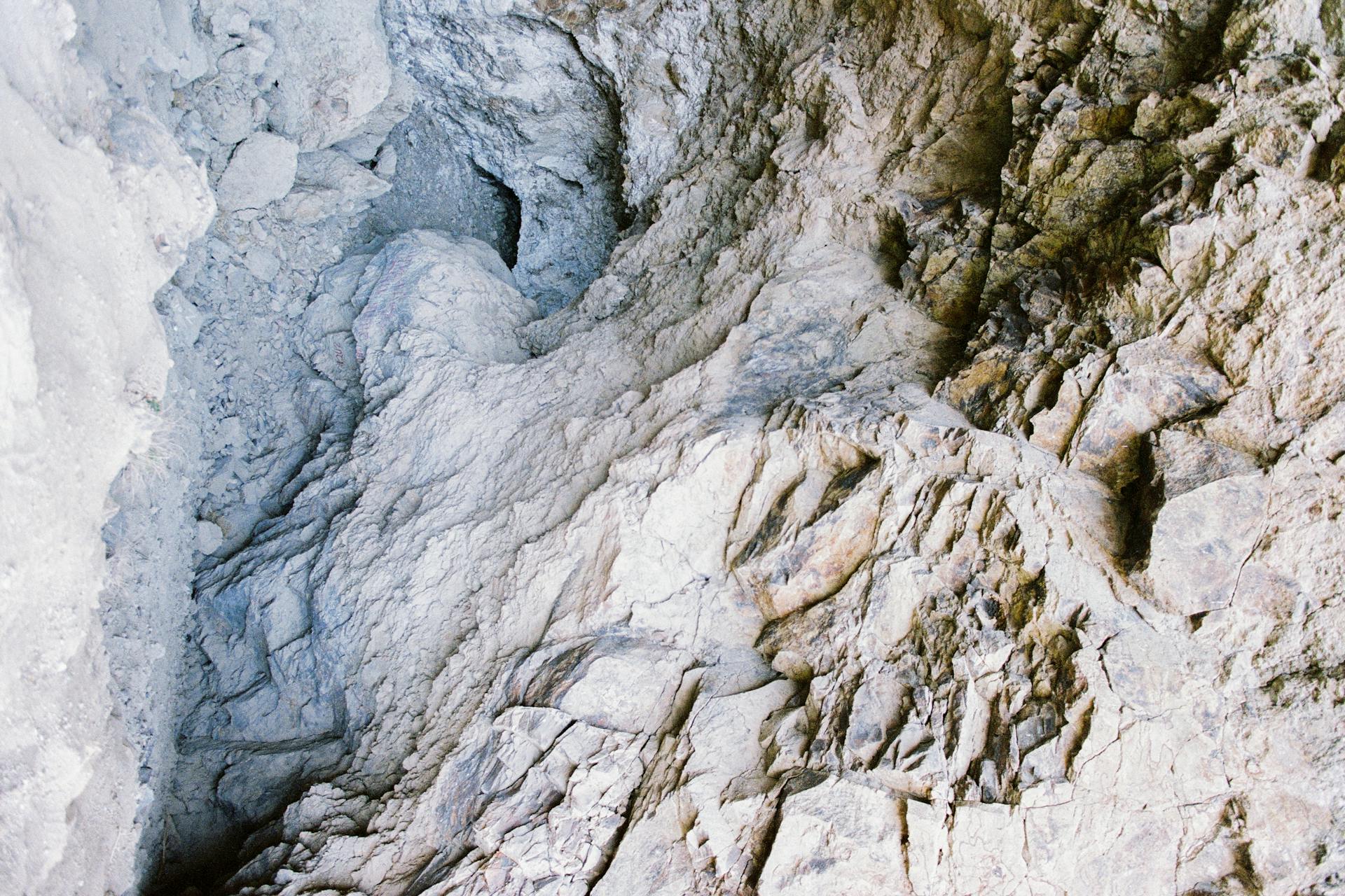 Explore the texture and geology of a rugged cave interior with intricate rock formations.