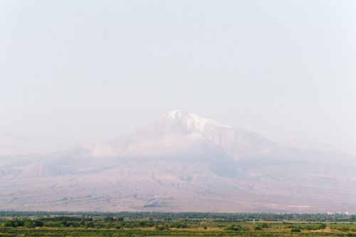 Free A serene view of a distant mountain range with snow-capped peaks under a clear sky. Stock Photo