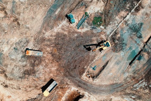 Free Aerial View Photography Of Utility Vehicles On Brown Soil Stock Photo