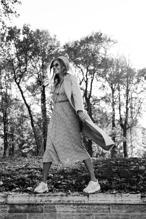 Free Stylish woman in fall attire, enjoying a walk outdoors in monochrome setting. Stock Photo