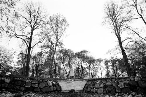 Free A black and white photo of a woman walking through an autumn forest, surrounded by trees. Stock Photo