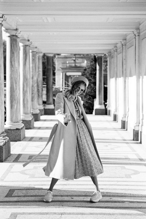 Free Elegant woman in black and white, standing in colonnade, wearing a stylish coat and beret. Stock Photo
