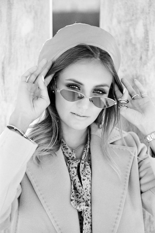 Free Black and white portrait of a stylish woman in a beret adjusting her sunglasses. Stock Photo
