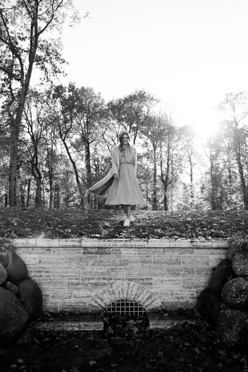 Free Graceful woman in dress stands amidst tall trees in a serene forest scene. Stock Photo