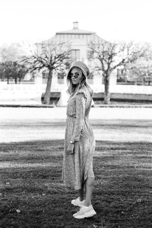 Free Elegant woman in a dress and hat standing outdoors in a park. Stock Photo