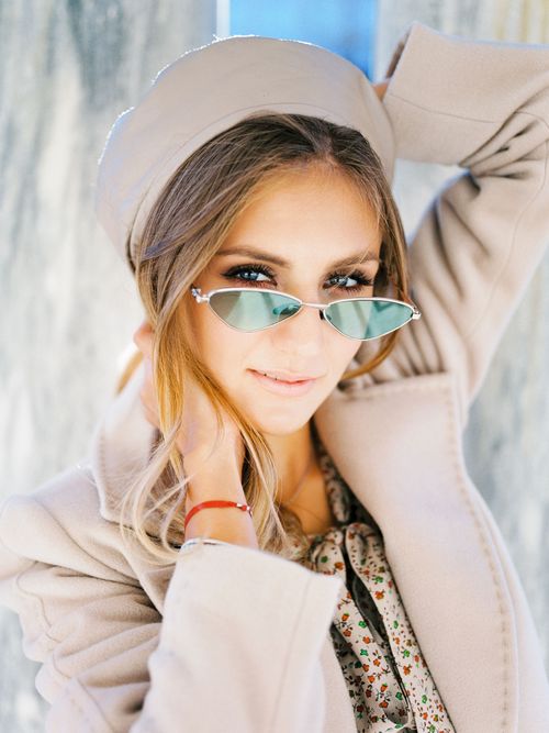 Free Fashionable woman wearing beige coat and hat, posing outdoors in sunglasses. Stock Photo